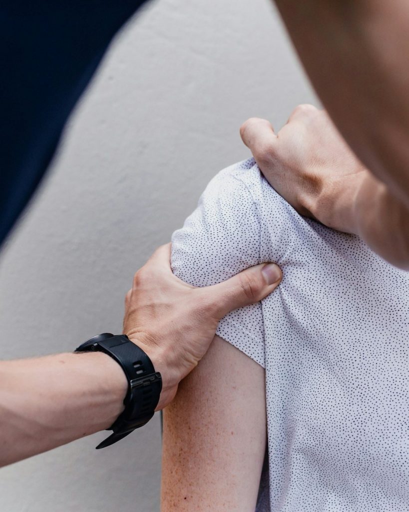 Fisioterapeuta avaliando o ombro de um paciente